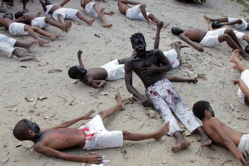 Foto de crianças e homens negros encenando.