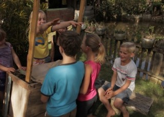 Foto de crianças brincando em volta de uma barraca.