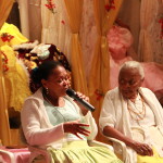 Foto ilustrando um diálogo entre pessoas , onde há duas mulheres negras , a mulher á direita possui um microfone á mão.